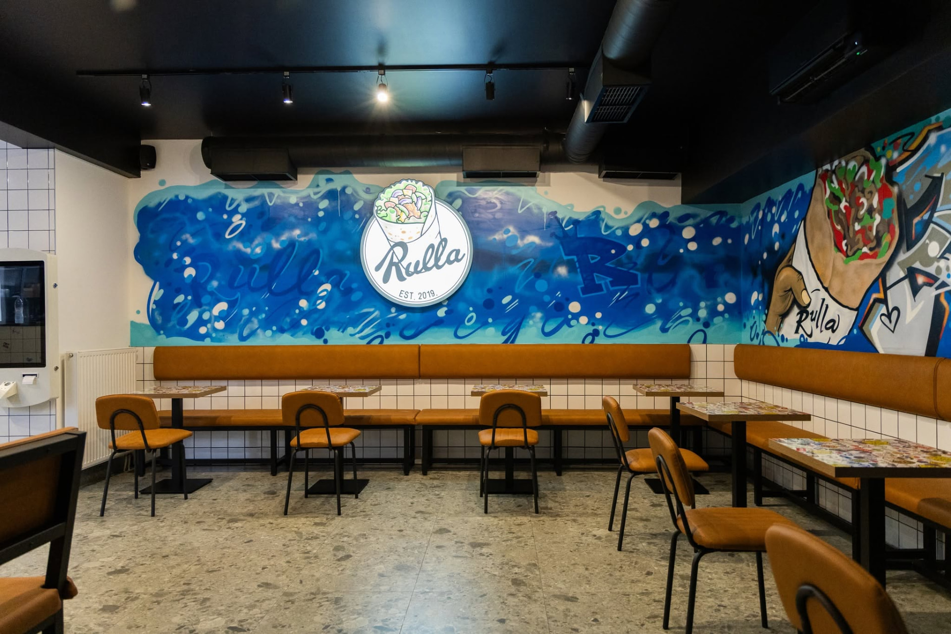 Interijer Rulla lokala s graffiti muralom i klupama